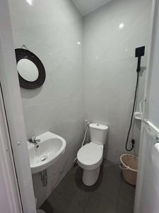 a white bathroom with a toilet and a sink at J20 Building Rental in Calatagan