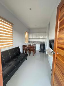 a living room with a black couch and a table at J20 Building Rental in Calatagan