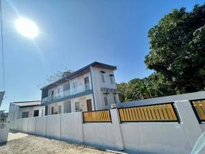 a white house behind a white fence with a fence at J20 Building Rental in Calatagan