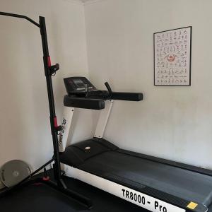 a gym with a treadmill and a phone on a wall at Workers Stay - Construction Worker Housing Sweden in Lund