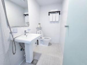 a white bathroom with a sink and a toilet at Ekonomy Hotel Myeongdong Premier in Seoul +30 photos