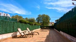 two chairs and a table on a patio at EVH114 Casa con piscina comunitaria in Altafulla