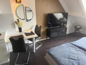 a bedroom with a bed and a desk with a television at Backboard in Tossens