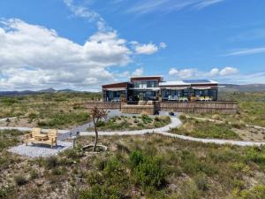 a house in the middle of a field at Walkerbay Dunes Lodge in Stanford