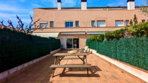 a picnic table on a patio in front of a building at EVH114 Casa con piscina comunitaria in Altafulla +34 photos