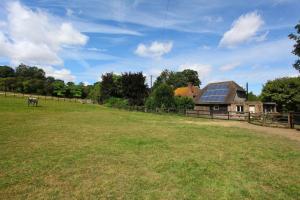 a large field with a house with a solar roof at Dulcie's Cottage in Wootton +2 photos