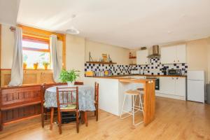 a kitchen with a table and a dining room at Dulcie's Cottage in Wootton