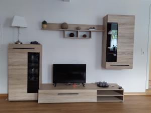 a living room with a tv and a wooden entertainment center at Ferienwohnung "Kleiner" EIFELTRAUM in Mettendorf