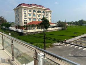 a large white building with a red roof at Thiên Nam Motel in Dien Ban
