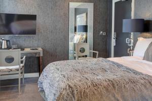 a bedroom with a bed and a desk and a mirror at The Bold Hotel; BW Signature Collection in Southport +116 photos