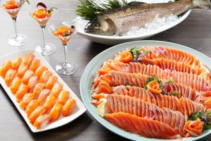 a table with three plates of fish and wine glasses at Hotel Green Plaza Hakuba in Otari