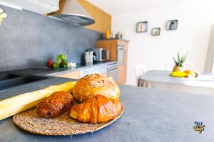 two loaves of bread and croissants on a counter in a kitchen at Côte et Mer in Wissant