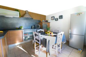 a kitchen with a table with chairs and a refrigerator at Côte et Mer in Wissant