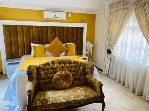 a bedroom with a king sized bed with a couch at Obaa Sima Guest House in Mthatha +26 photos