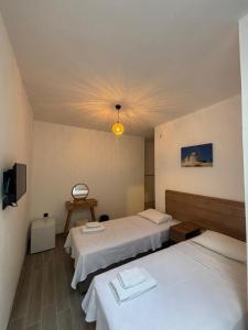 a hotel room with two beds and a tv at Kırçak Konak in Çeşme