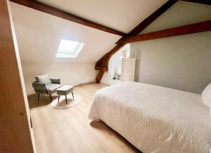 a bedroom with a white bed and a chair at Chambre avec Salle de Bain Privative in Tarbes