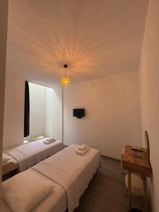 a room with two beds and a light on the ceiling at Kırçak Konak in Çeşme
