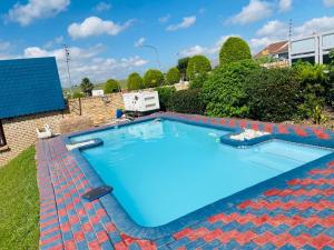 a large blue swimming pool with a brick wall at Obaa Sima Guest House in Mthatha
