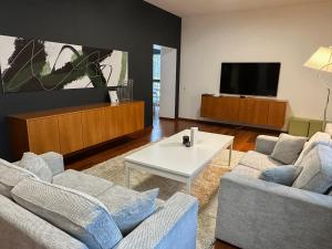 a living room with two couches and a tv at GMP Clubhotel Apartments in Otepää