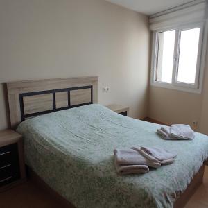 a bedroom with a bed with two towels on it at Malpica I in Malpica