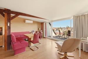 a living room with a pink couch and a table at SONN IDYLL Aparthotel in Rathenow