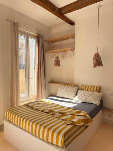a bedroom with a bed with a striped blanket at LaFrenchCasa Canebière in Marseille