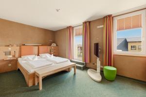 a bedroom with a bed and a television in it at SONN IDYLL Aparthotel in Rathenow