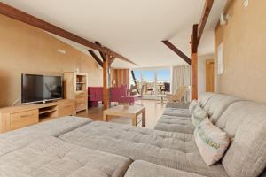 a living room with two couches and a television at SONN IDYLL Aparthotel in Rathenow