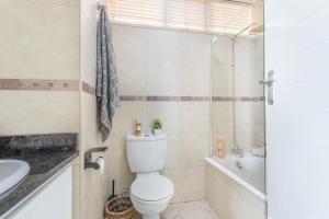 a bathroom with a toilet and a tub and a sink at Sea View Luxury Penthouse in Ballito +27 photos