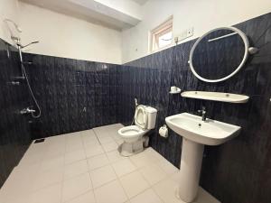 a bathroom with a sink and a toilet and a mirror at Hotel Highnest in Bandarawela +18 photos
