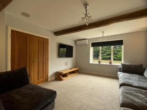 a living room with a couch and a window at Welcome To Wrexham - Hot Tub Luxury 5 bed House in Holt