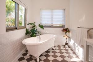a white bathroom with a tub and a window at ocean10 Guesthouse in Cape Town +39 photos