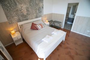a bedroom with a white bed with two pillows on it at Open Space Suite in the Center of Salerno, modern apartment into Historic District, 250 meters from seafront and 20 meters from the Main Street Corso Garibaldi in Salerno