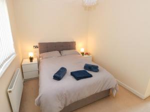 a bedroom with a bed with two blue towels on it at Swansea Escape in Swansea