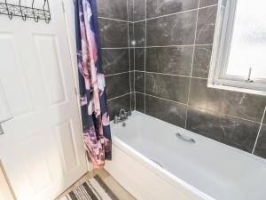 a bathroom with a tub and a shower curtain at Swansea Escape in Swansea