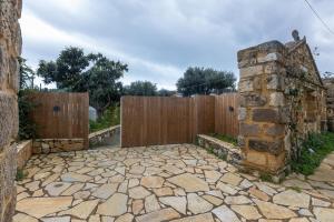 a stone patio in front of a wooden fence at Sarantou House in Koroni