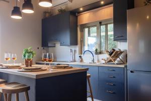 a kitchen with blue cabinets and a counter with glasses of wine at Sarantou House in Koroni +44 photos
