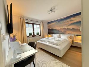 a bedroom with a bed and a desk with a laptop at Ferienwohnung Pistenblick in Winterberg +37 photos