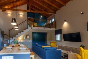 a living room with a table and blue chairs at Sarantou House in Koroni
