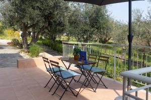 a table and chairs on a patio with an umbrella at Sarantou House in Koroni