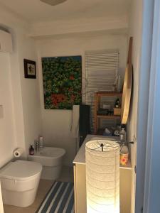 a bathroom with a white toilet and a sink at Loft Crimea con patio in Turin +15 photos