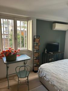 a bedroom with a bed and a table with flowers on it at Loft Crimea con patio in Turin
