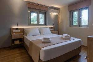 a bedroom with a large bed with two towels on it at Sarantou House in Koroni