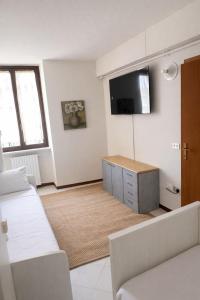 a living room with a couch and a tv on the wall at Vinessa Rooms in Sirmione