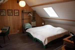 a bedroom with a bed in a attic at L' Ancienne Ecole du Morvan in Larochemillay