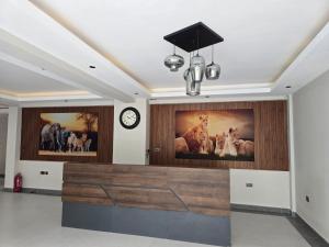 a lobby with a clock and paintings on the wall at Oloisiri Namanga Hotel in Namanga