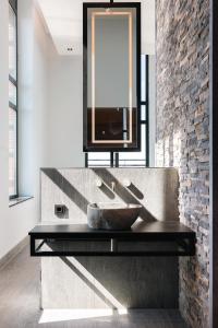 a bathroom with a stone sink and a mirror at Van der Valk Hotel Houten Utrecht in Houten
