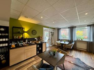 a living room with a table and a dining room at Hotel Garni am Obsthof Stade - Altes Land in Stade