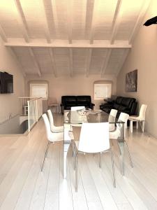 a living room with a glass table and white chairs at Budello di Alassio, ampio appartamento con box vicino al mare in Alassio