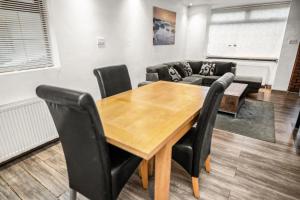 a dining room with a wooden table and black chairs at Central Manchester Family-Friendly Home with Free Parking and Workspace in Manchester
